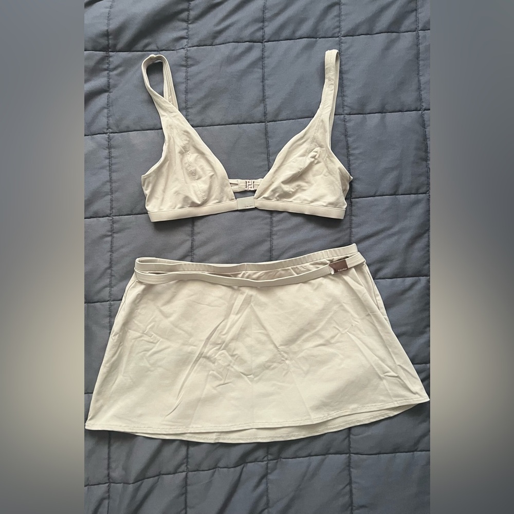 3 piece swimsuit by Calvin Klein. Size 12 on top/bottom & size M on skirt. Used.